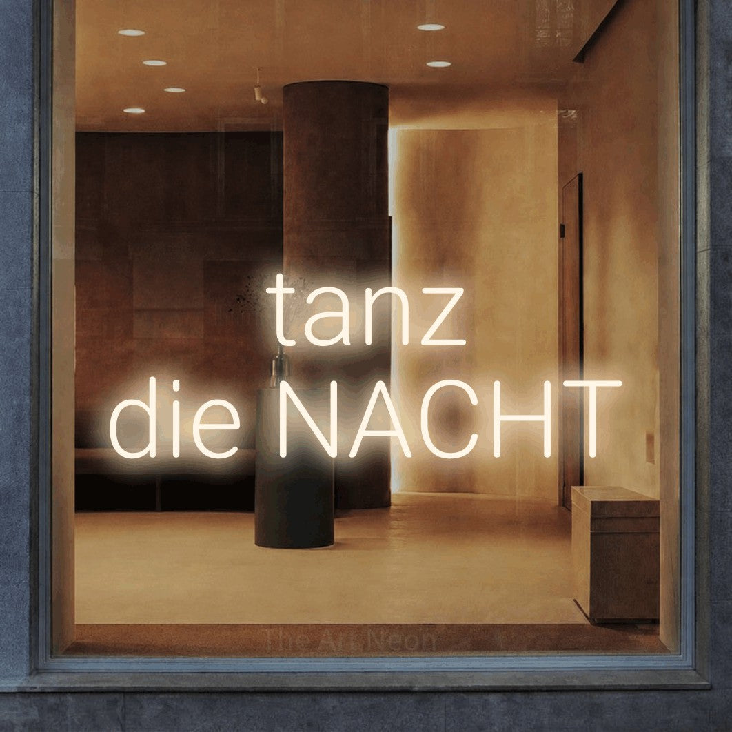 LED neon sign reading “tanz die NACHT”, arranged in 2 lines.