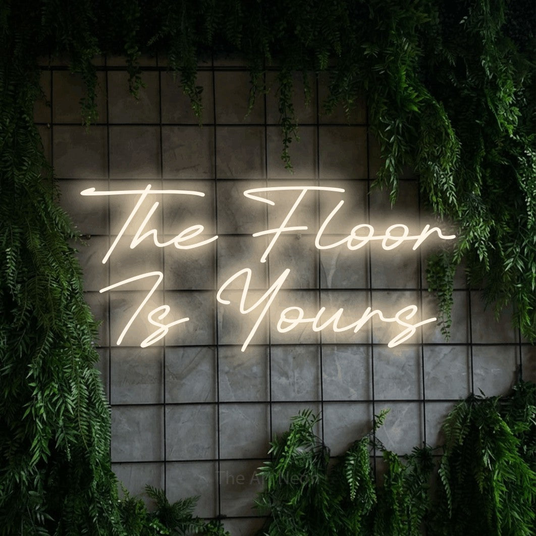 LED neon sign displaying “The Floor Is Yours”.