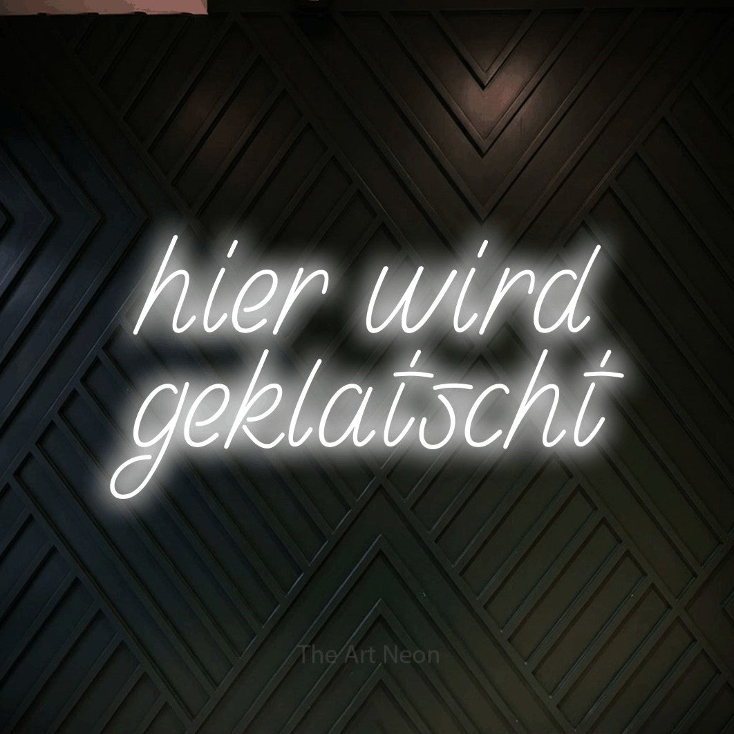 LED neon sign reading “hier wird geklatscht”, arranged in 2 lines.