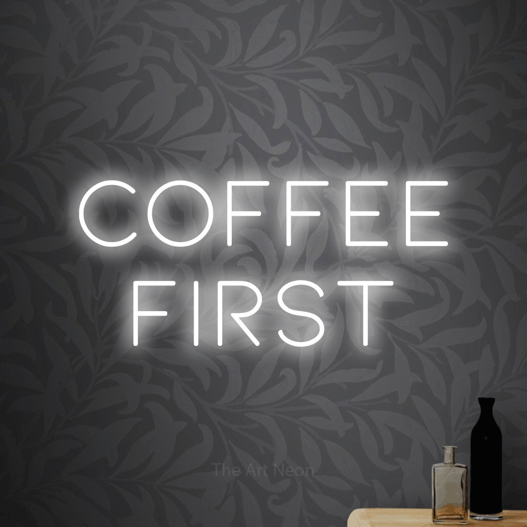 LED neon sign reading “Coffee first”, arranged in 2 lines.