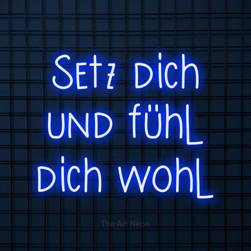 LED neon sign reading “Setz dich und fühl dich wohl”, arranged in 3 lines.