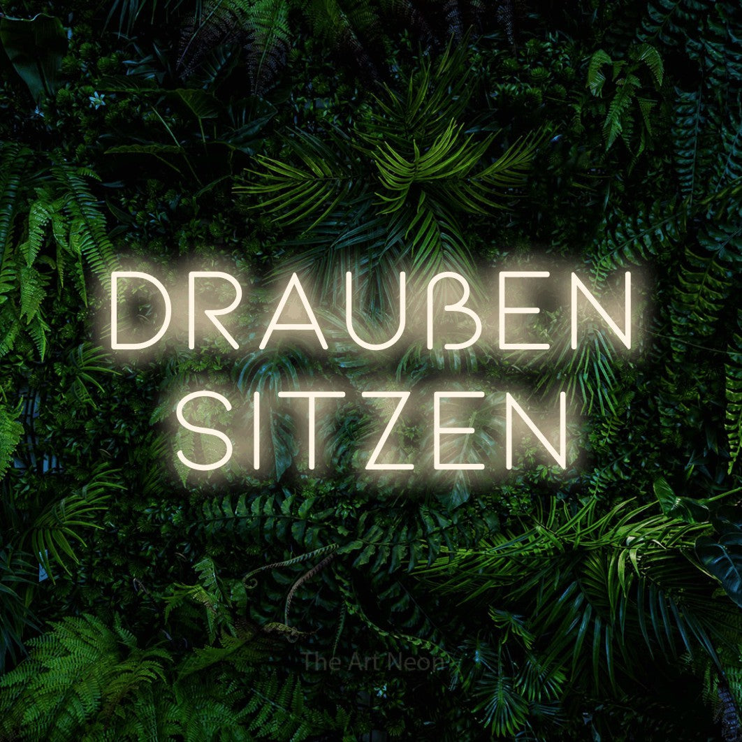 LED neon sign reading “Draußen sitzen”, arranged in 2 lines.