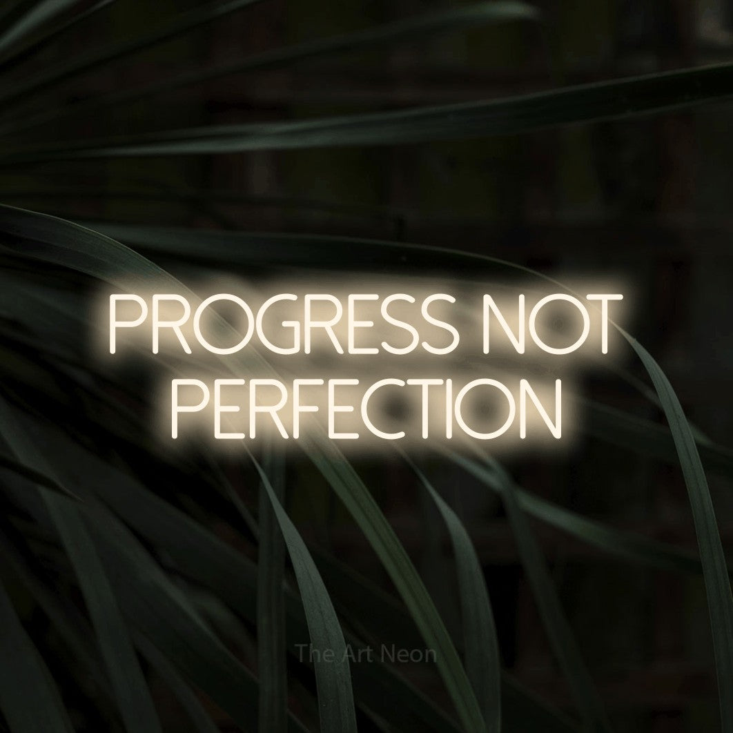 LED neon sign reading “progress not perfection”, arranged in 2 lines.