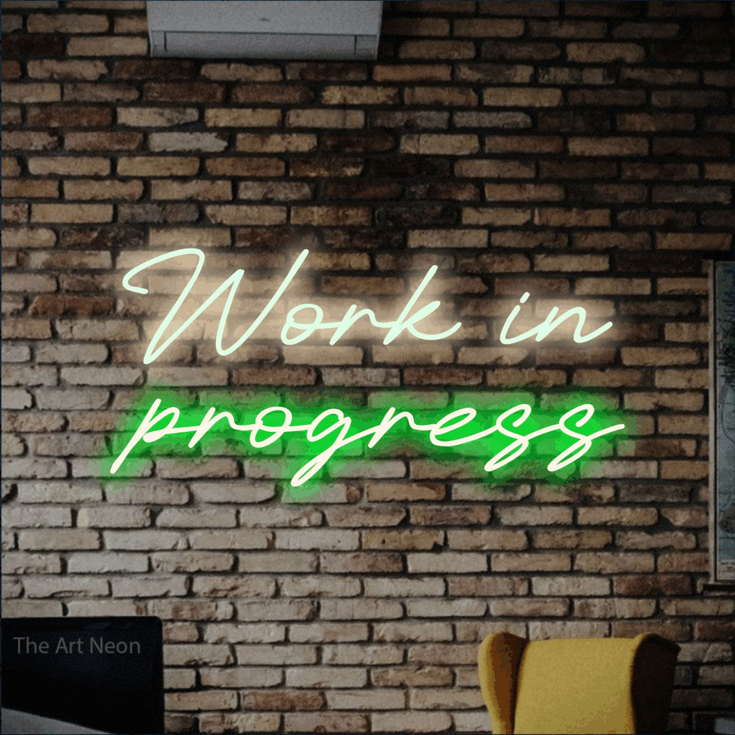 LED neon sign reading “Work in progress”, arranged in 2 lines.