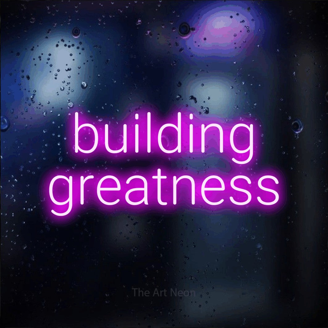 LED neon sign reading “building greatness”, arranged in 2 lines.