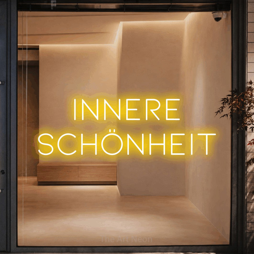 LED neon sign reading “INNERE SCHÖNHEIT”, arranged in 2 lines.