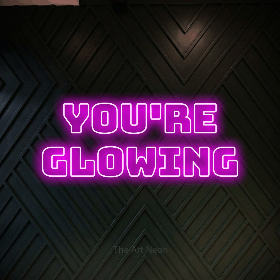 LED neon sign reading “You're glowing”, arranged in 2 lines.