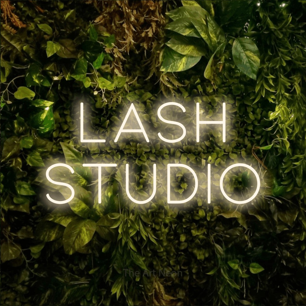 LED neon sign reading “lash STUDIO”, arranged in 2 lines.