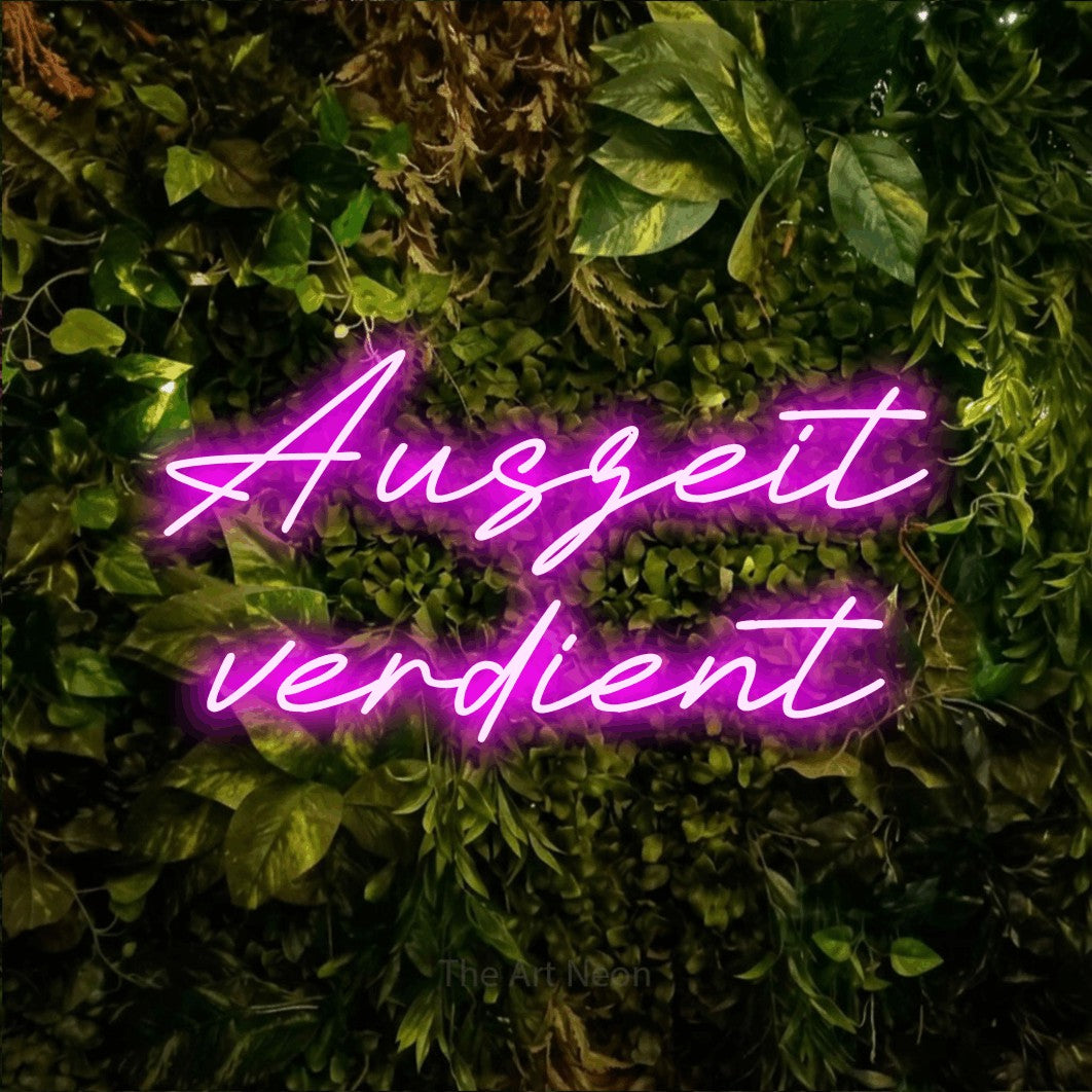 LED neon sign reading “Auszeit verdient”, arranged in 2 lines.