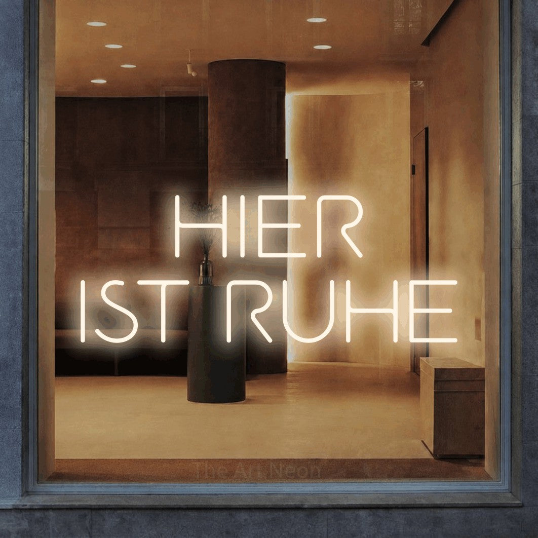 LED neon sign reading “HIER IST RUHE”, arranged in 2 lines.