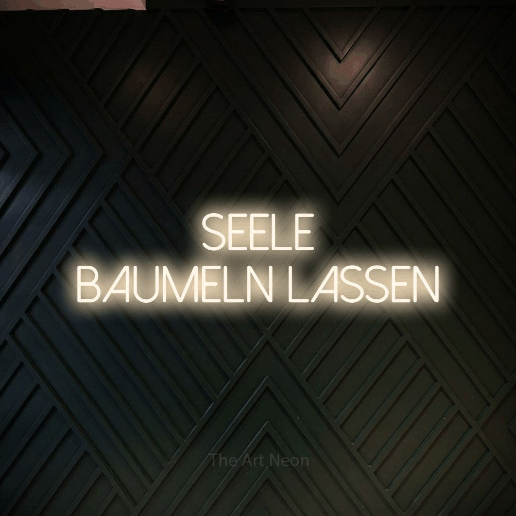 LED neon sign reading “Seele baumeln lassen”, arranged in 2 lines.
