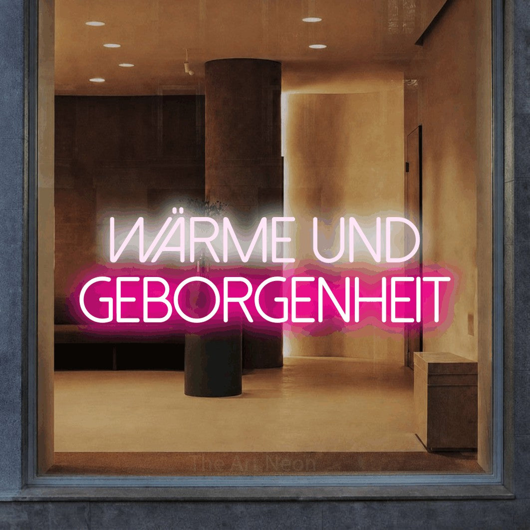 LED neon sign reading “Wärme und Geborgenheit”, arranged in 2 lines.