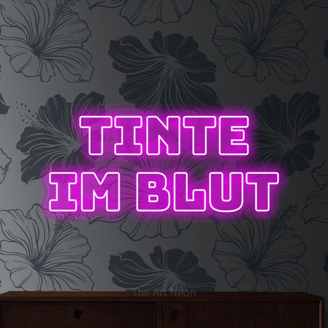 LED neon sign reading “Tinte im Blut”, arranged in 2 lines.