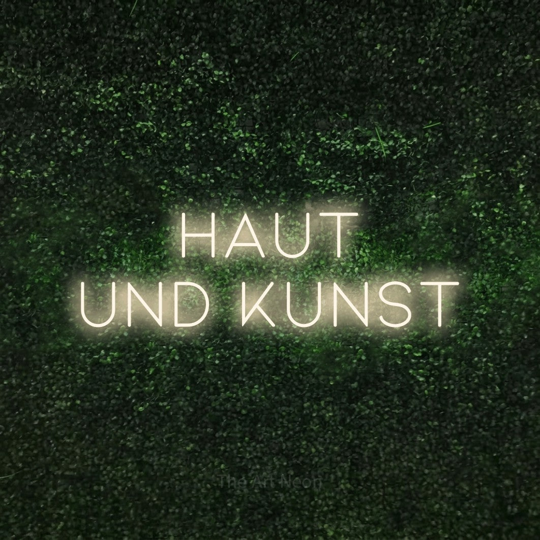 LED neon sign reading “Haut und Kunst”, arranged in 2 lines.