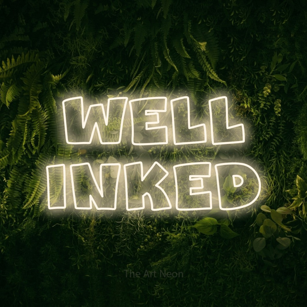 LED neon sign reading “well inked”, arranged in 2 lines.