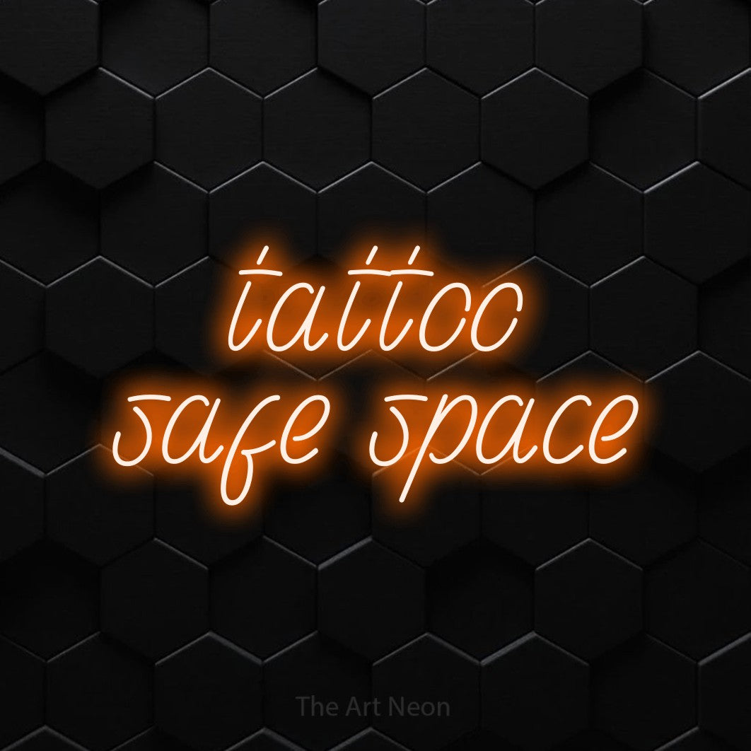 LED neon sign reading “tattoo safe space”, arranged in 2 lines.