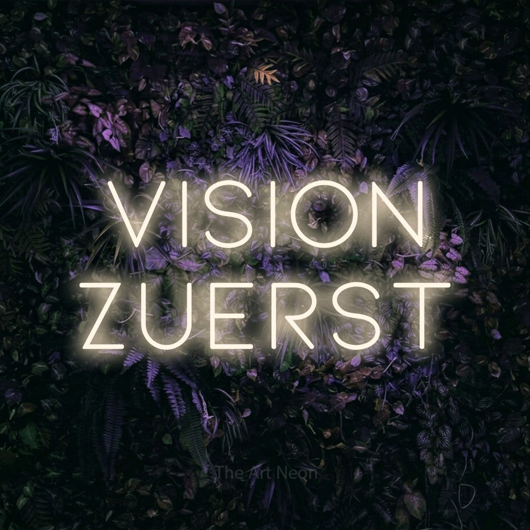 LED neon sign reading “vision zuerst”, arranged in 2 lines.
