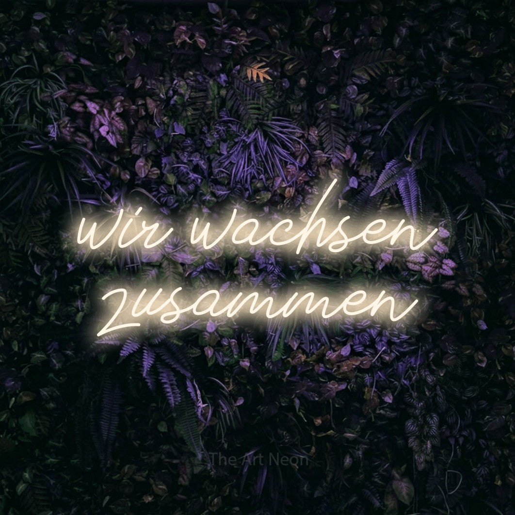 LED neon sign reading “wir wachsen zusammen”, arranged in 2 lines.