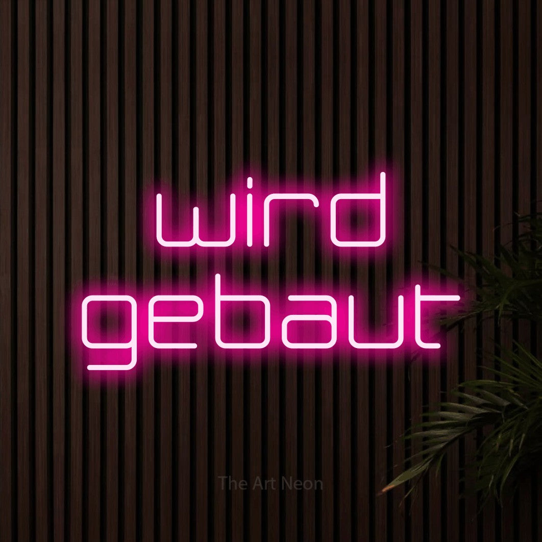 LED neon sign reading “wird gebaut”, arranged in 2 lines.