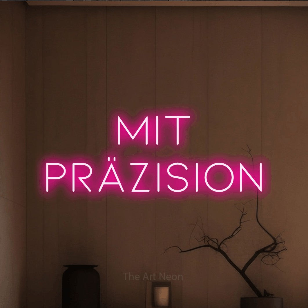 LED neon sign reading “Mit Präzision”, arranged in 2 lines.