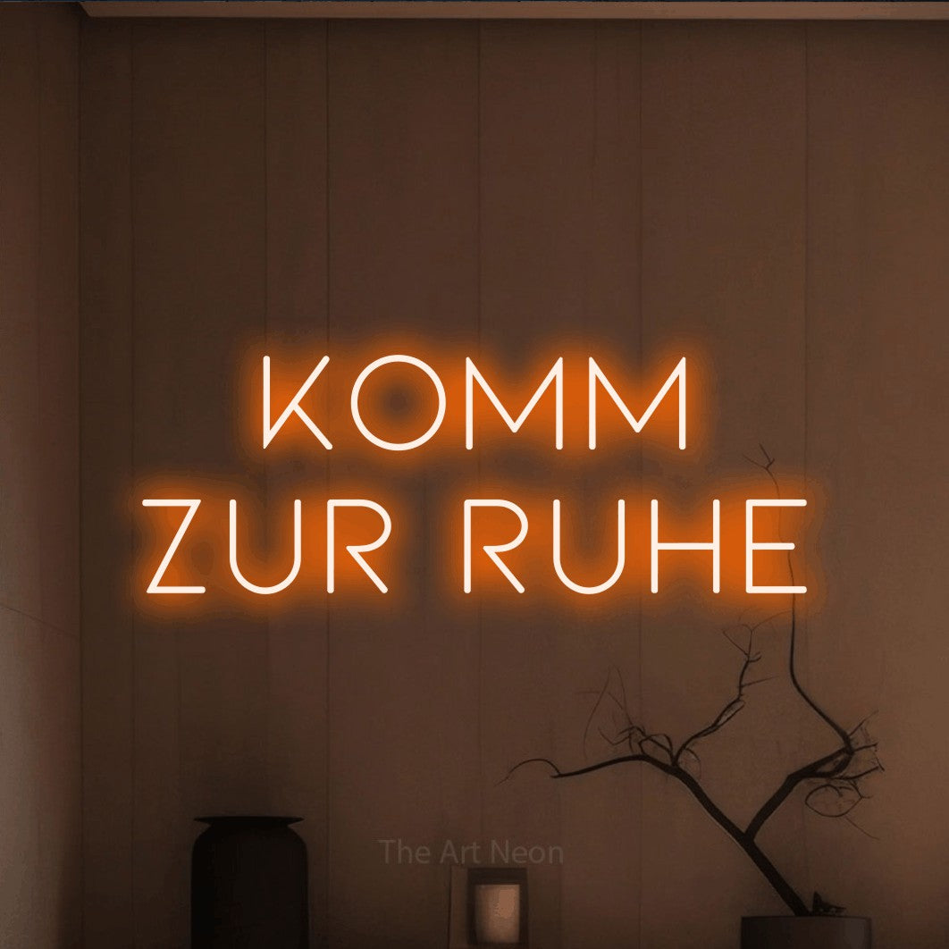 LED neon sign reading “KOMM ZUR RUHE”, arranged in 2 lines.