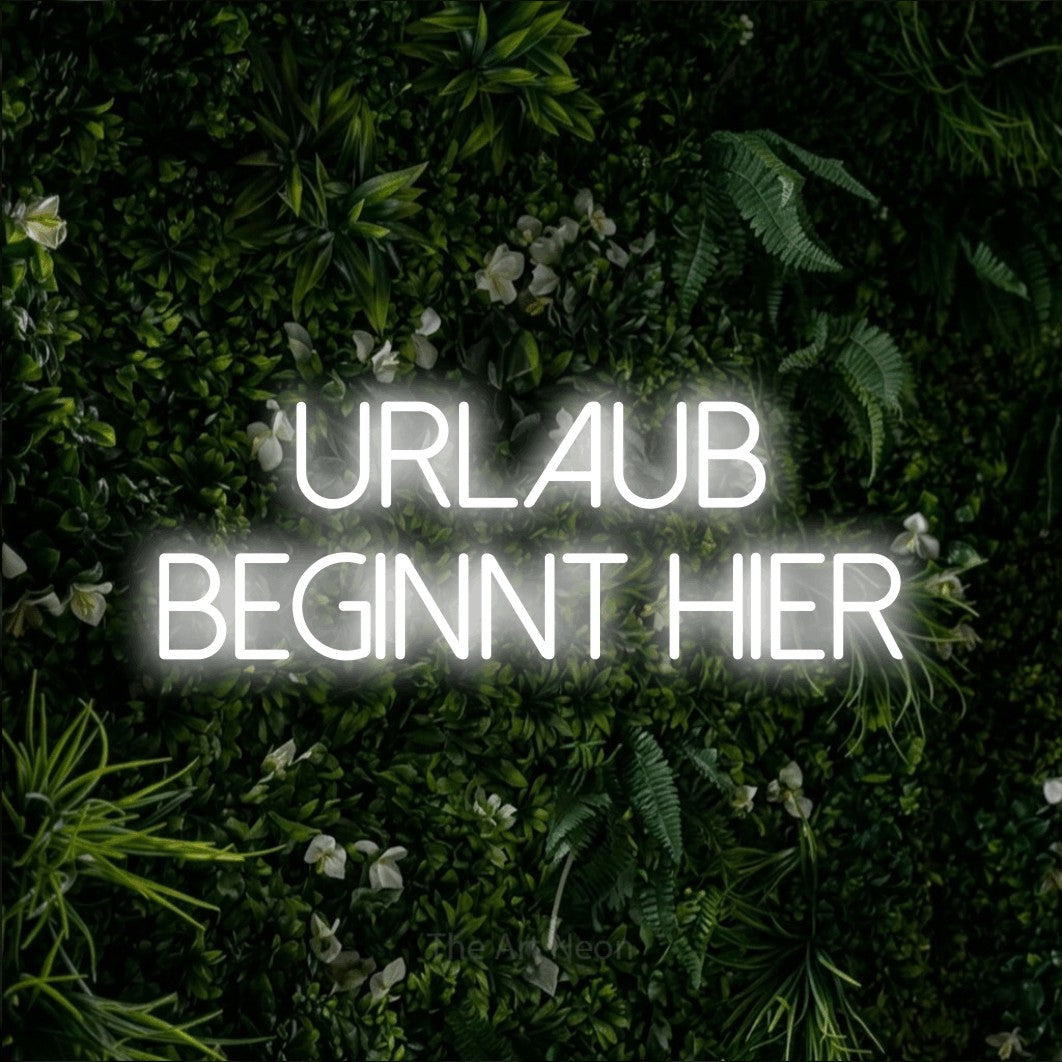 LED neon sign reading “urlaub beginnt hier”, arranged in 2 lines.