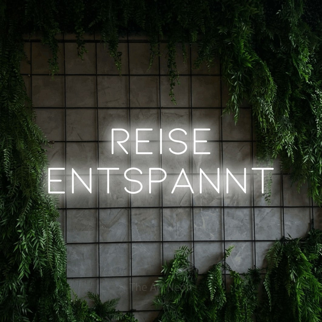 LED neon sign displaying “reise entspannt”.