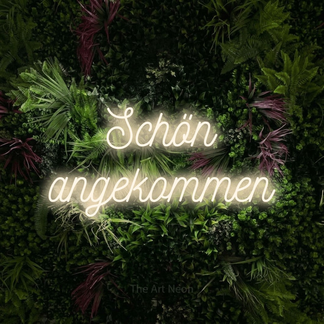 LED neon sign reading “Schön angekommen”, arranged in 2 lines.