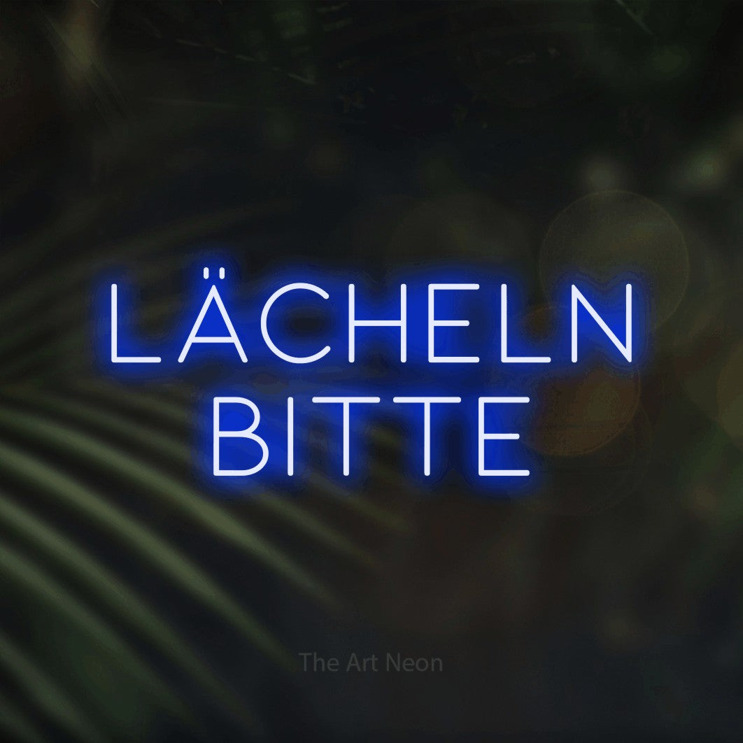 LED neon sign reading “Lächeln bitte”, arranged in 2 lines.