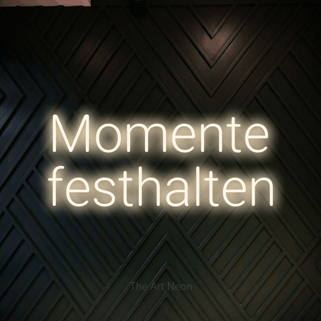 LED neon sign reading “Momente festhalten”, arranged in 2 lines.