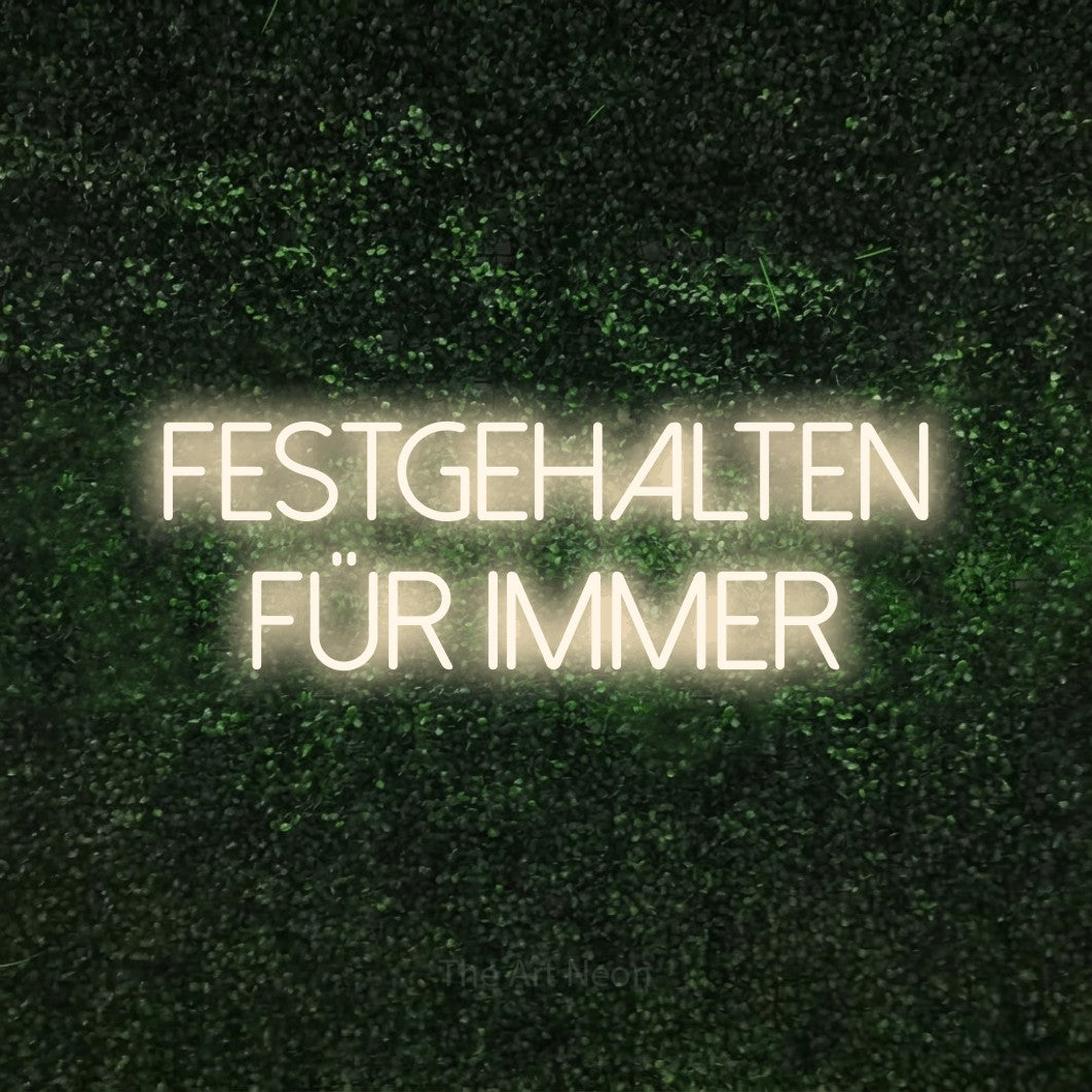 LED neon sign reading “Festgehalten für immer”, arranged in 2 lines.