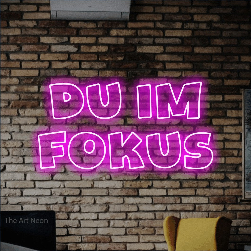 LED neon sign reading “du im fokus”, arranged in 2 lines.