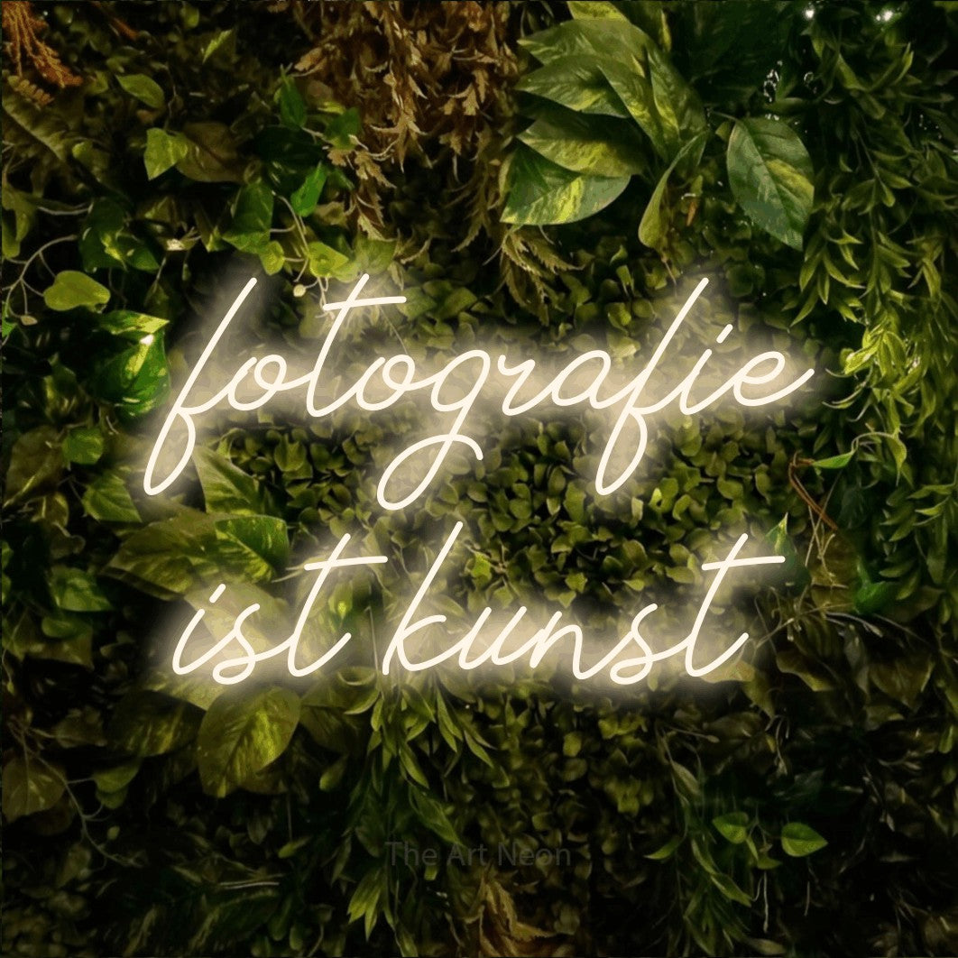 LED neon sign reading “fotografie ist kunst”, arranged in 2 lines.