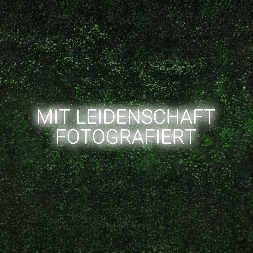 LED neon sign reading “MIT LEIDENSCHAFT FOTOGRAFIERT”, arranged in 2 lines.