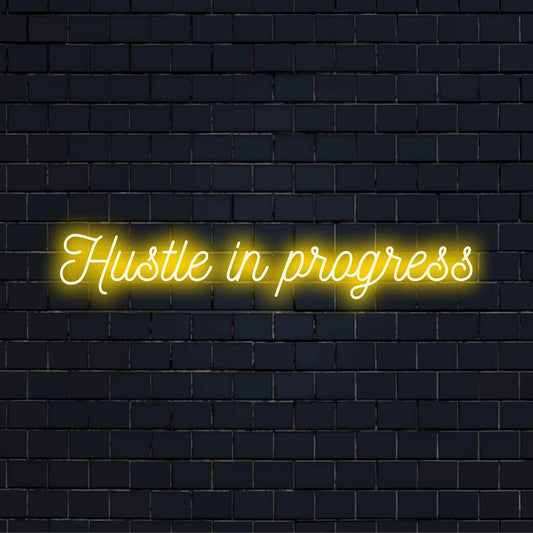 Custom made LED neon sign reads Hustle In Progress, ideal for motivational decor in home or office spaces.