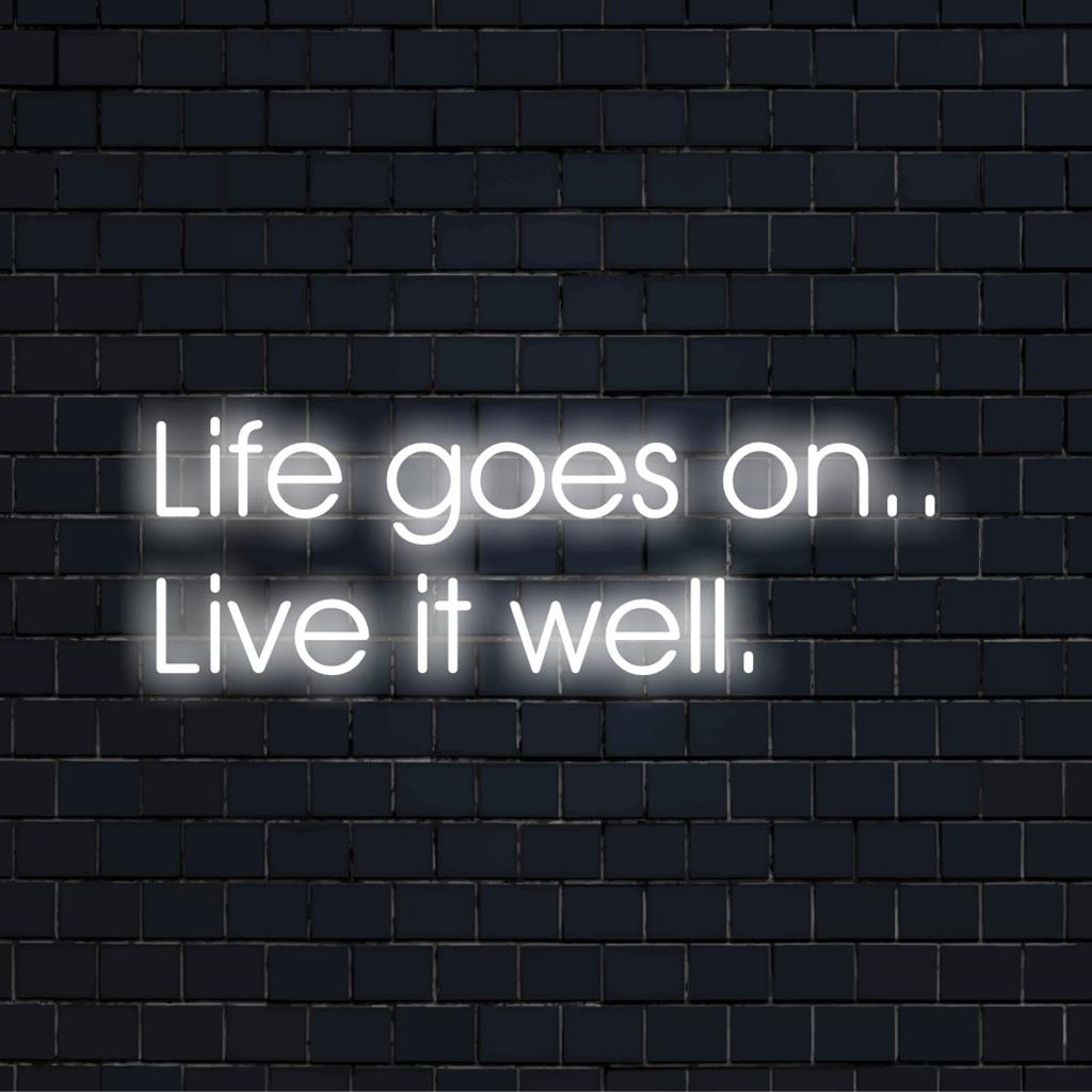Das LED-Schild „Life Goes On.. Live It Well“ leuchtet in leuchtenden Farben; ein motivierendes Neon-Zitat-Kunstwerk für jeden Raum.