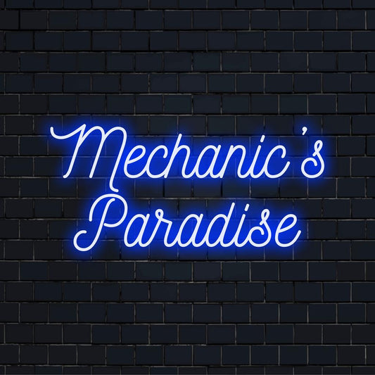 Custom neon sign reading Mechanic's Paradise in vibrant LEDs, perfect for personalized neon decor in a workshop setting.