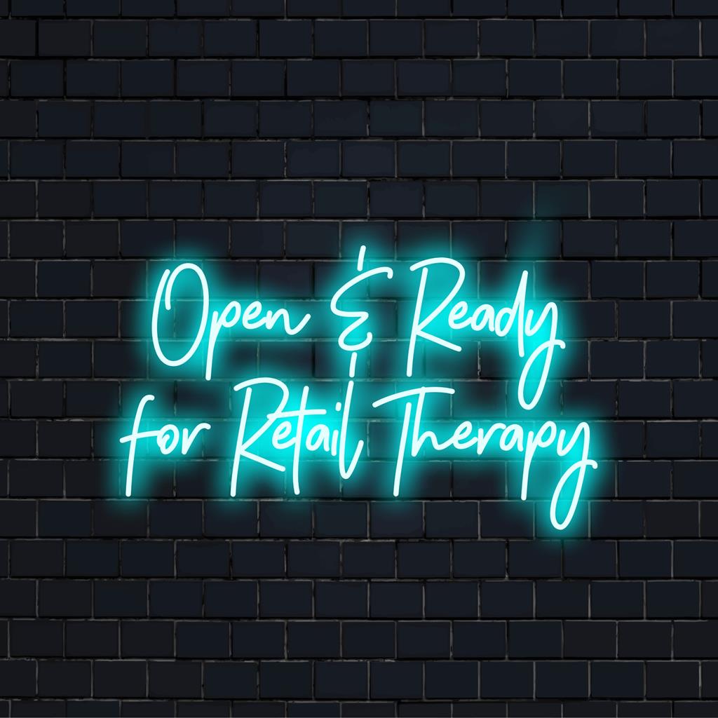 Custom LED neon sign reads Open Ready For Retail Therapy in vibrant light, perfect for neon light decor in your boutique or store.