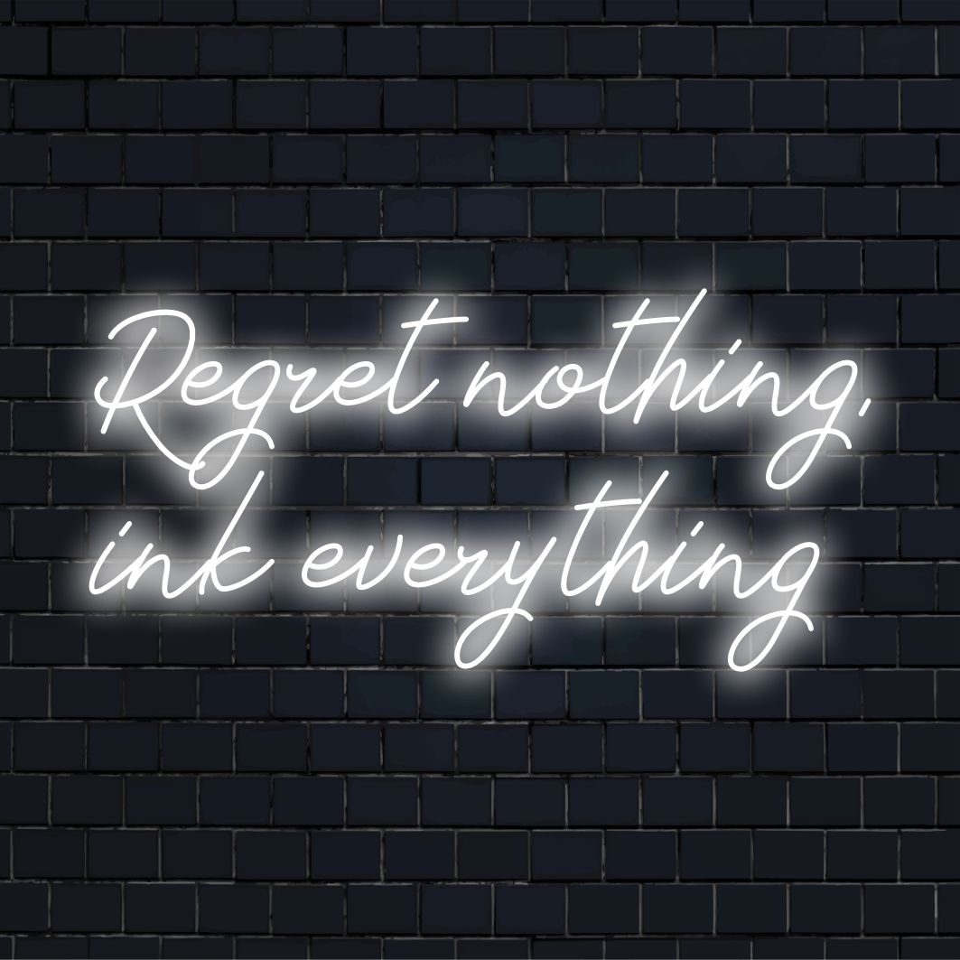 Custom LED neon sign with the phrase Regret Nothing, Ink Everything, perfect for personalizing spaces with vibrant energy.