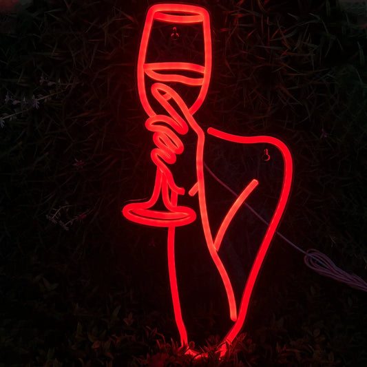 The image showcases a vibrant LED neon sign depicting an outline of a woman holding a wine glass.