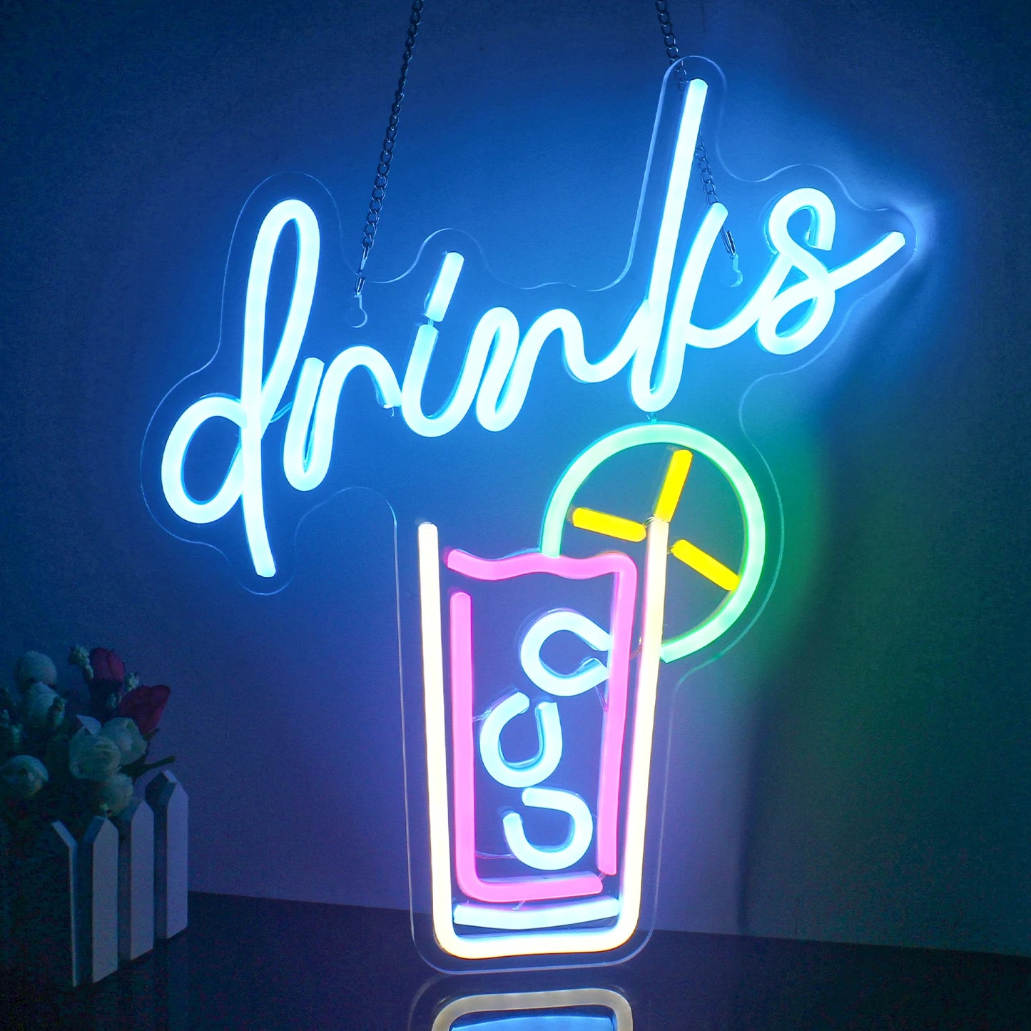 The image features a vibrant, handmade LED neon sign displaying the word "Drinks" in an elegant and stylish cursive font.