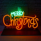 Ein leuchtendes LED-Neonschild mit der Aufschrift „Frohe Weihnachten“ mit fettem, kursivem Schriftzug in leuchtendem Rot.