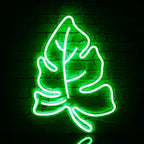 Das Bild zeigt ein leuchtendes LED-Neonschild in Form eines grünen Blattes.