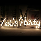 Das Bild zeigt ein lebendiges, handgefertigtes LED-Neonschild mit der Aufschrift „Let’s Party“ in verspielter Schreibschrift.