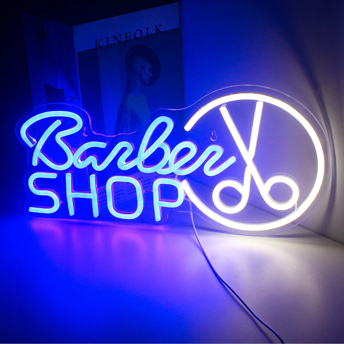 Ein leuchtendes LED-Neonschild mit dem Wort „Barbershop“ in Schreibschrift, hellweiß beleuchtet.