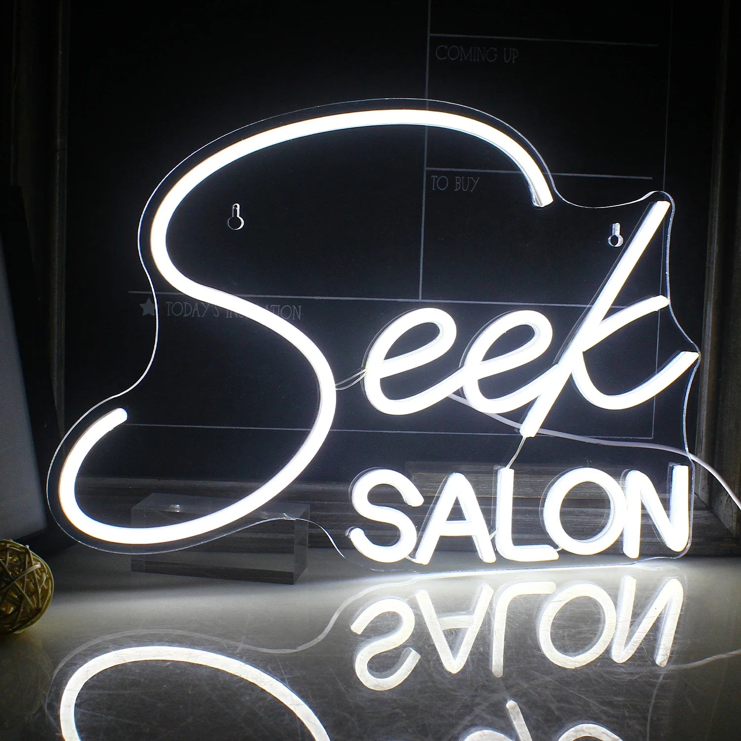 The image features a vibrant LED neon sign displaying the word "SALON" in stylized, uppercase letters.