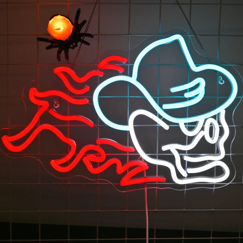 Das Bild zeigt ein leuchtendes LED-Neonschild in Form eines Totenkopfes mit Cowboyhut.