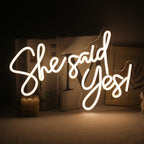 A vibrant, handmade LED neon sign displaying the phrase "She Said Yes.