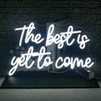 The image showcases a vibrant, handmade LED neon sign that reads "The Best is Yet to Come" in a stylish, cursive font.