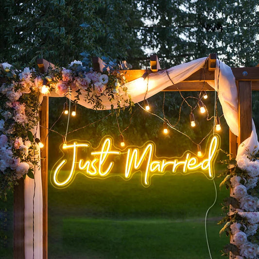 A glowing LED neon sign displaying the words "Just Married" in elegant, cursive script.